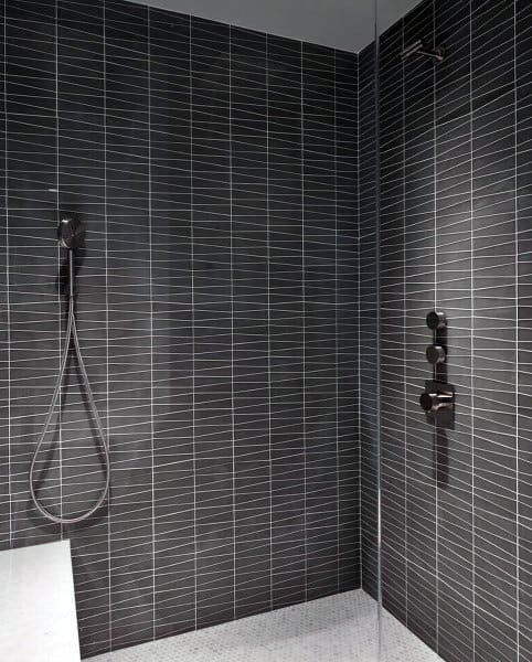 Black beveled tile shower with sleek matte black fixtures and glass enclosure.