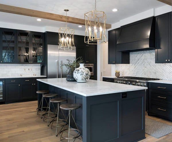 Kitchen with dark cabinets, marble island, wooden beams, pendant lights, and herringbone backsplash.