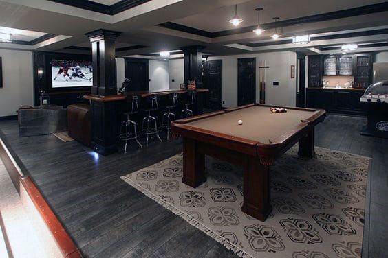 dark hardwood flooring basement movie room with billiards table