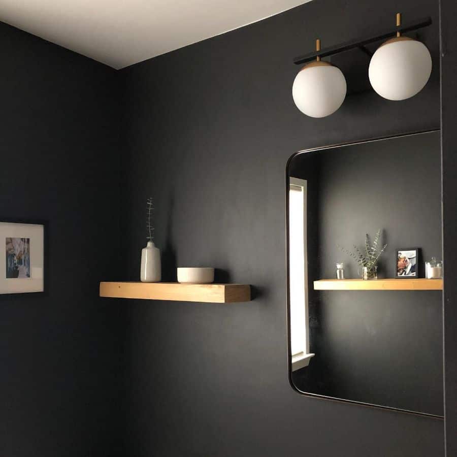black wall powder room with wood shelving 