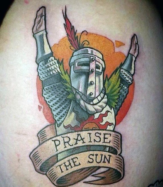 Cartoon-style tattoo of Solaire of Astora with arms raised, sun in the background, and a flowing banner that reads “Praise the Sun.”