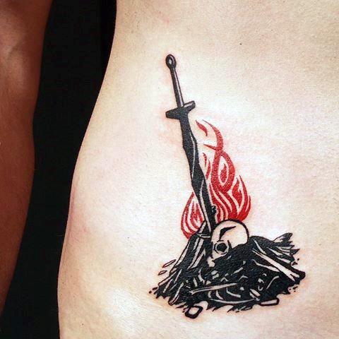 Minimalist Dark Souls tattoo of a bonfire with a sword, skull, and red flames, symbolizing rest and rebirth in the game.