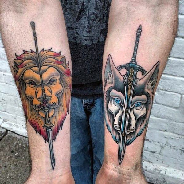 Matching forearm tattoos inspired by Dark Souls, featuring a lion and wolf split by swords in bold, colorful style.