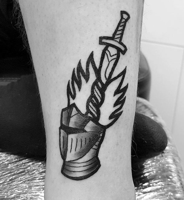Bold blackwork Dark Souls tattoo of a knight’s helmet with a flaming sword emerging from it, symbolizing the bonfire and heroism.