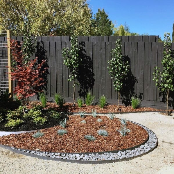 black painted wood fence with landscaping garden