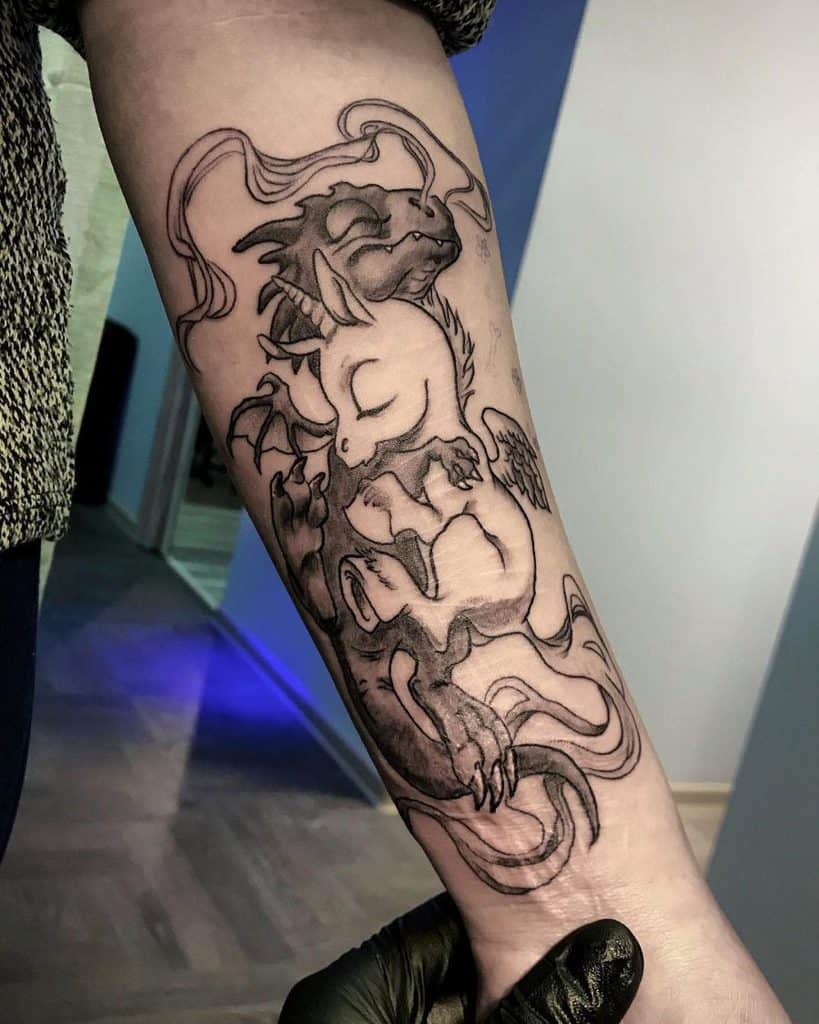 Black and grey tattoo of a sleeping unicorn and dragon intertwined, symbolizing harmony between mythical creatures with flowing smoke-like details.