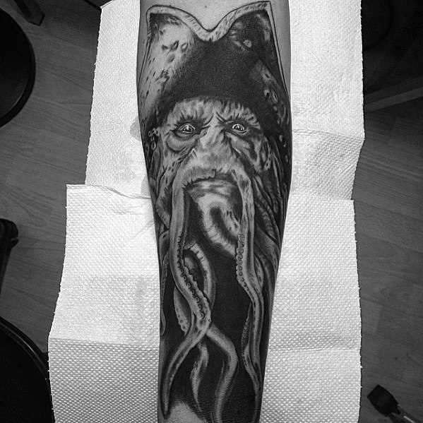 Tattoo of a bearded pirate with Davy Jones's tentacles on a forearm