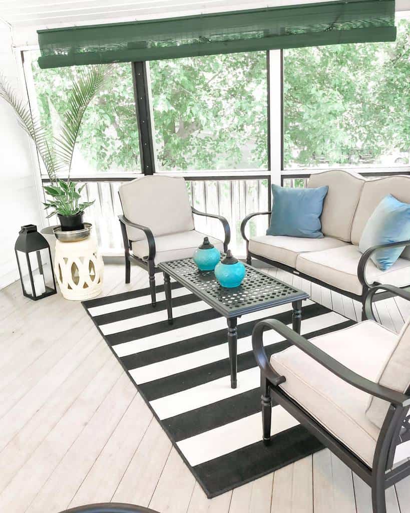 simple wood deck enclosed patio black metal table and chairs sofa black and white floor rug
