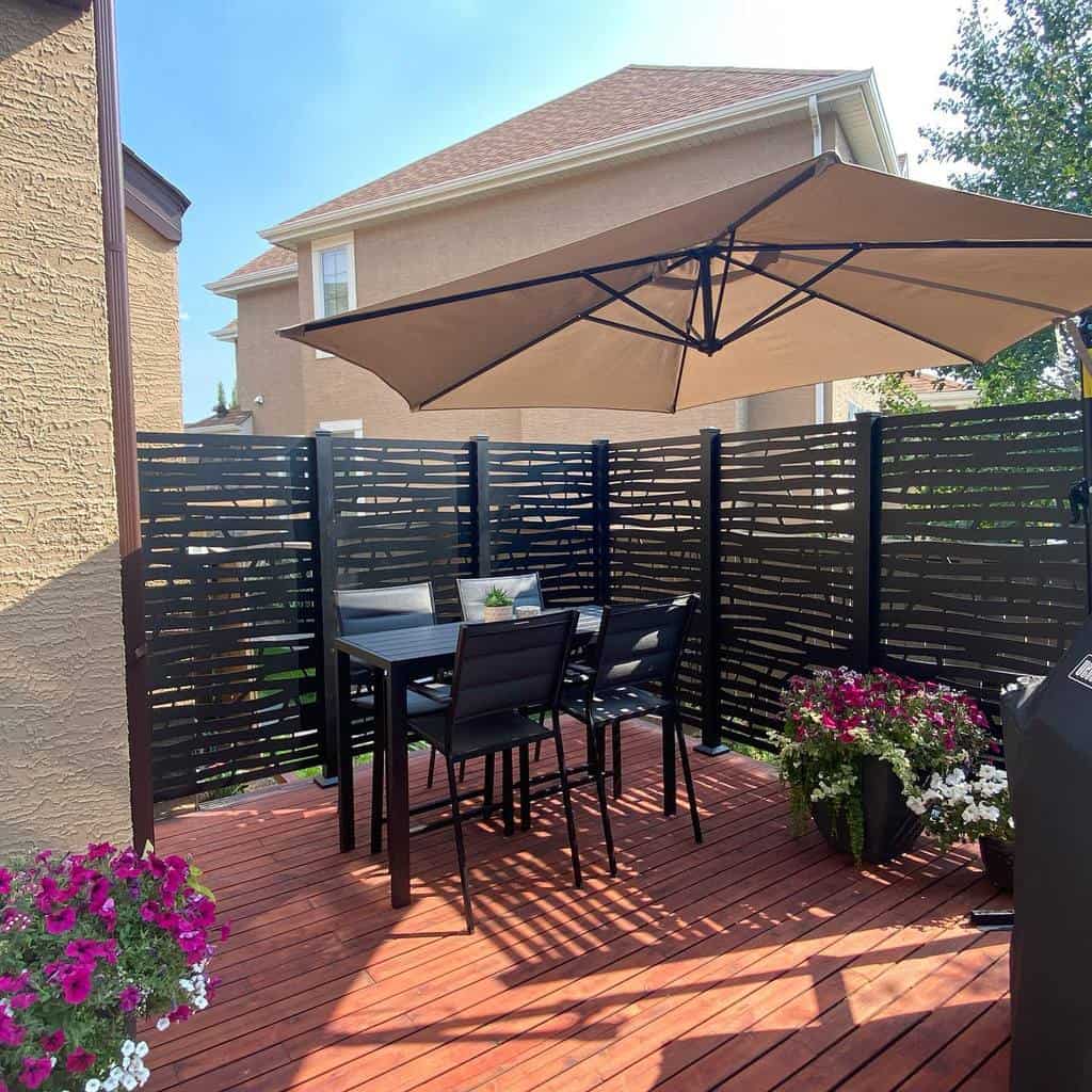 deck patio with black privacy fence and umbrella shade