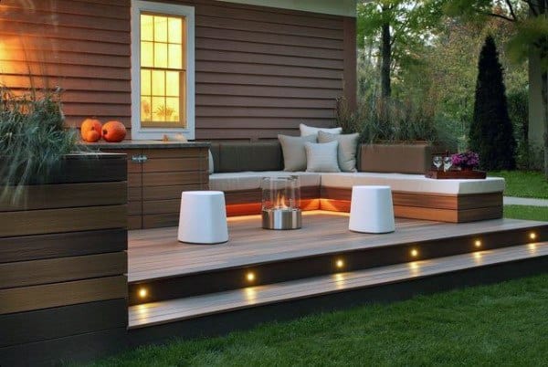 Cozy backyard deck with built-in seating, warm lighting, and modern decor.
