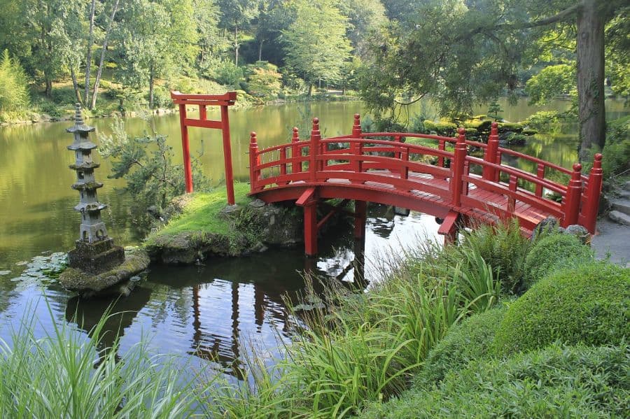 wood red bridge leading to stone temple statue 