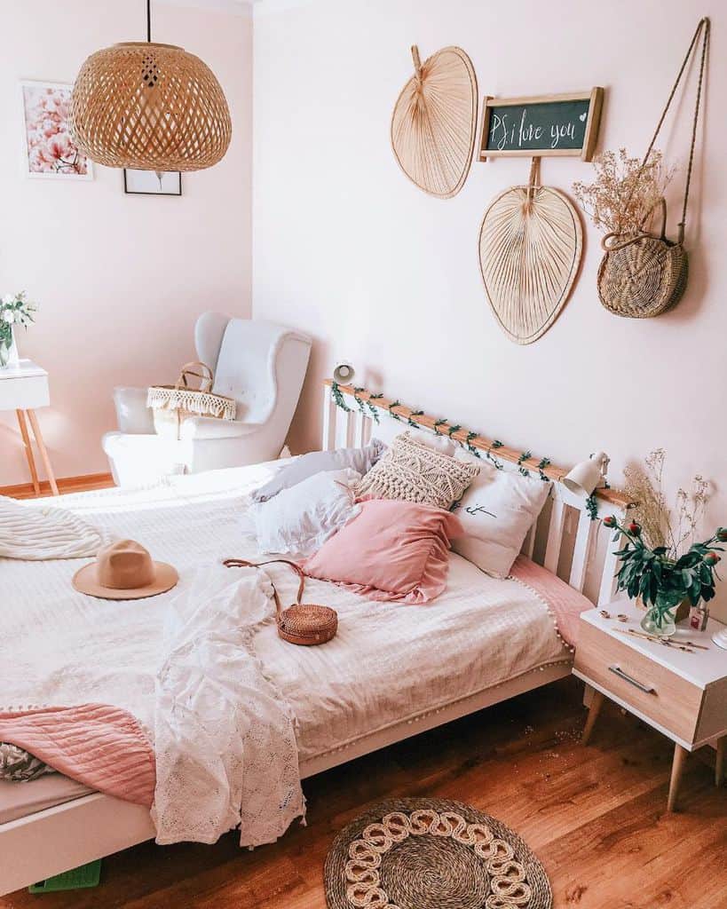 Boho-style bedroom with pink accents, woven decor, and cozy bedding.
