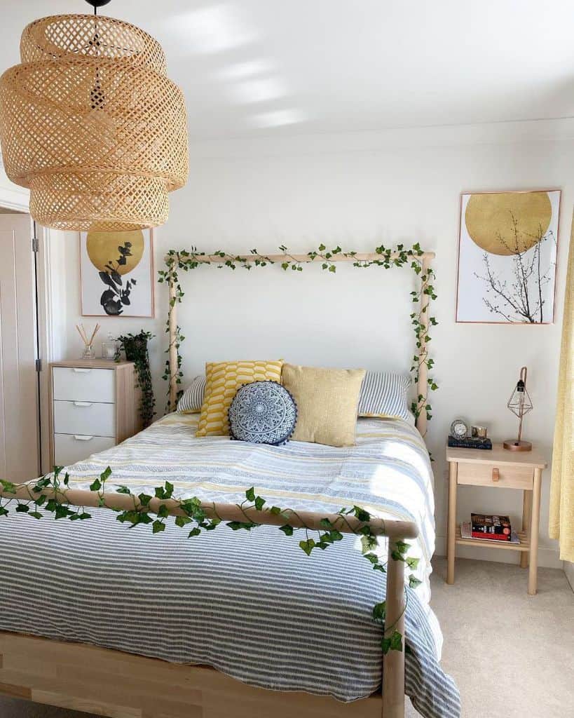 Bright bedroom with four-poster bed, vine decor, striped bedding, and woven pendant light.