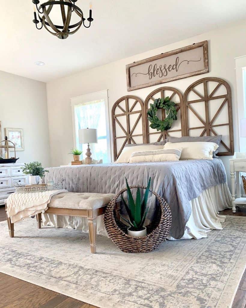 Cozy farmhouse bedroom with rustic design, featuring a bed, wooden decor, plants, and a chandelier