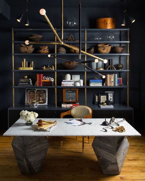 Modern office with a geometric desk, eclectic shelving, books, and a unique chandelier