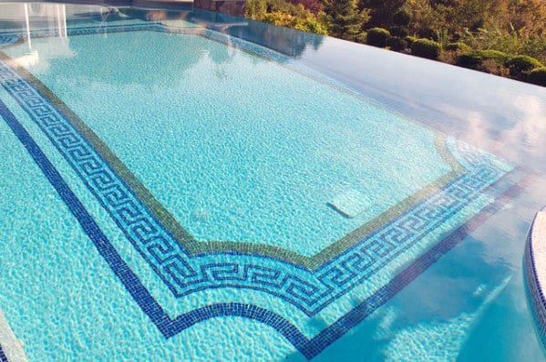 Infinity pool with turquoise water and decorative Greek key mosaic tile border design.