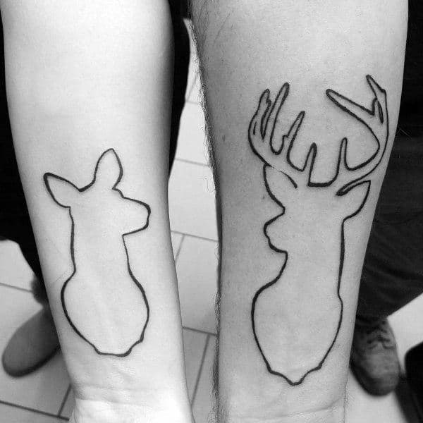 Matching forearm tattoos of minimalist doe and stag outlines, symbolizing love, loyalty, and a strong bond between soulmates.