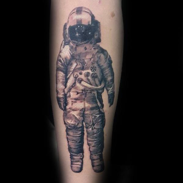 Realistic black and grey Deja Entendu astronaut tattoo with detailed shading on a plain background.