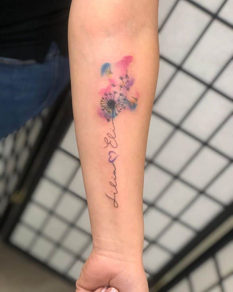 A colorful tattoo with a dandelion, seeds floating away, and a heartfelt signature beneath it: "Alina ❤️ Elia."