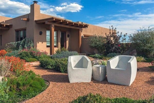 desert garden with gravel pathway two white stone chairs and small table 