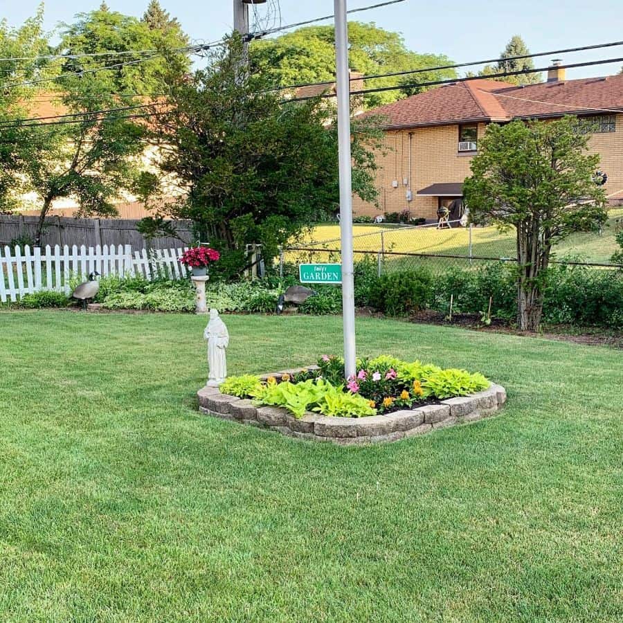 small stone garden bed middle of the lawn
