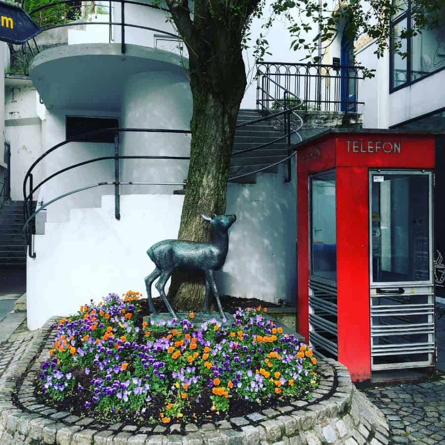 stone garden bed with flowers and deer statue