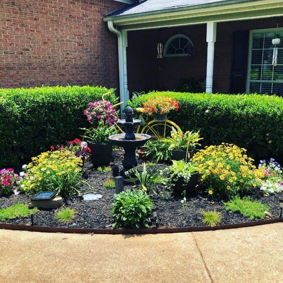front yard flower bed stone fountain