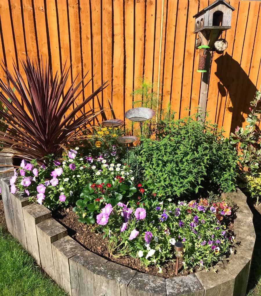 wood fence backyard flower bed bird house