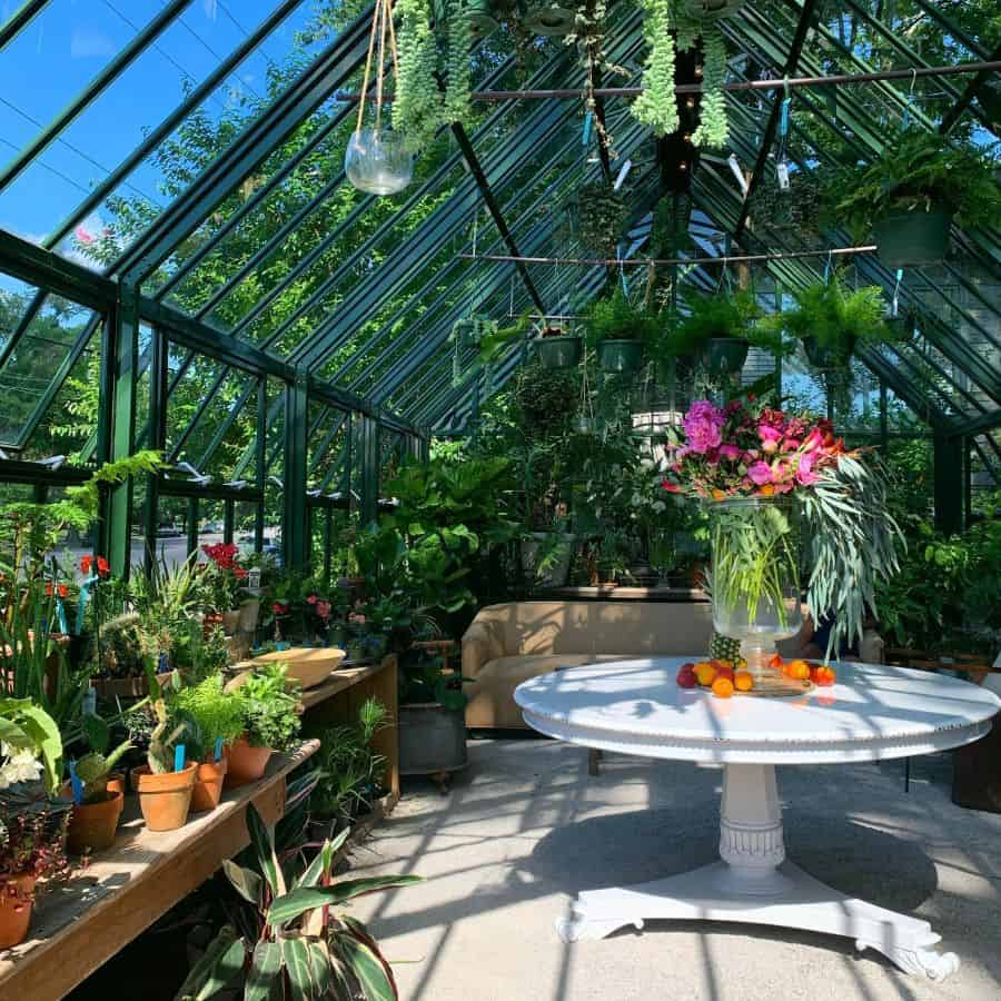 large backyard greenhouse white table colorful flowers sofa