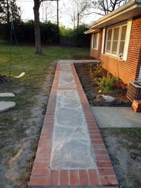 Brick and stone walkway leading to a house