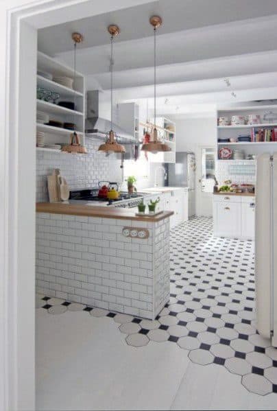 Charming tile-to-wood floor transition featuring black and white hexagonal tiles flowing seamlessly into a bright modern kitchen