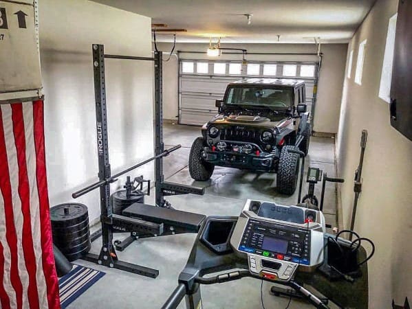 Garage gym with squat rack, weight plates, and treadmill in a compact setup.