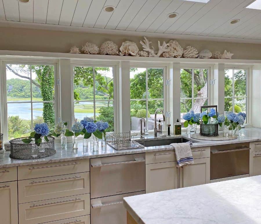 large kitchen windows with wall shelf holding items from the sea