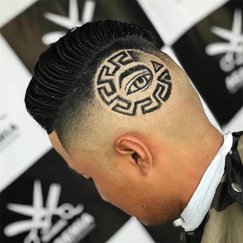 A medium burst fade haircut with an eye design slightly at the back of one ear