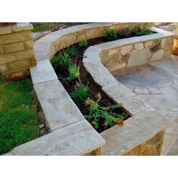 Stone planter bench with integrated garden bed and rustic patio design.