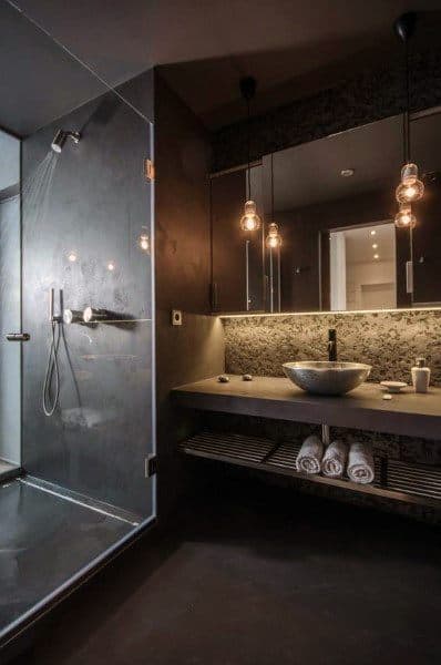 Modern bathroom with a glass shower, floating sink, and pendant lights