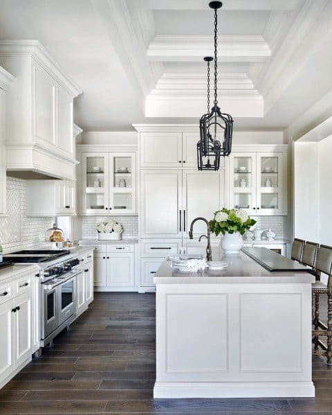 A bright white kitchen featuring elegant crown molding, modern pendant lighting, and clean cabinetry for a sophisticated, timeless look