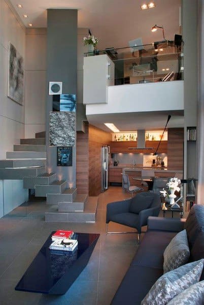 Modern loft with floating staircase, glass mezzanine, and sleek open kitchen design.