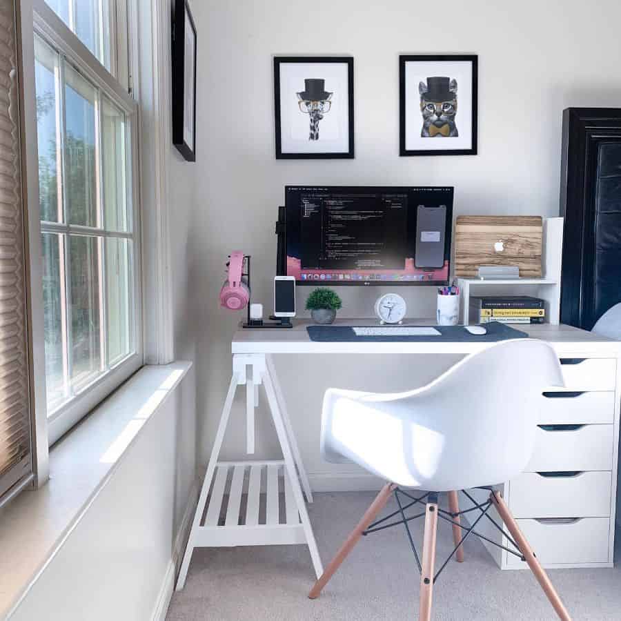 Modern home office with white desk, computer, decor, and framed animal art.