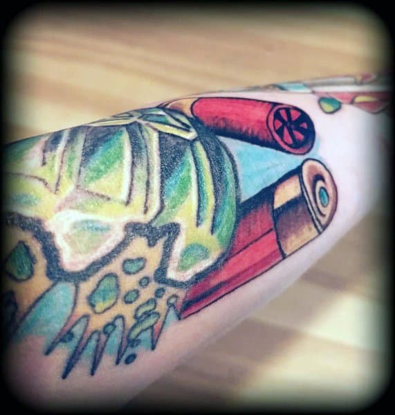 Colorful shotgun shell tattoo with bold red and gold casings, featuring dynamic shading and a vibrant background for a striking design.