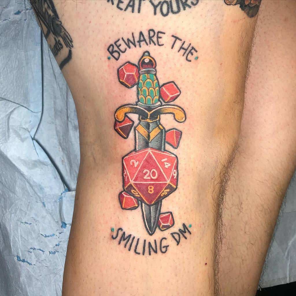 A vibrant tattoo with a sword and D20 dice, captioned 'Beware the Smiling DM,' blending colorful details and fantasy elements