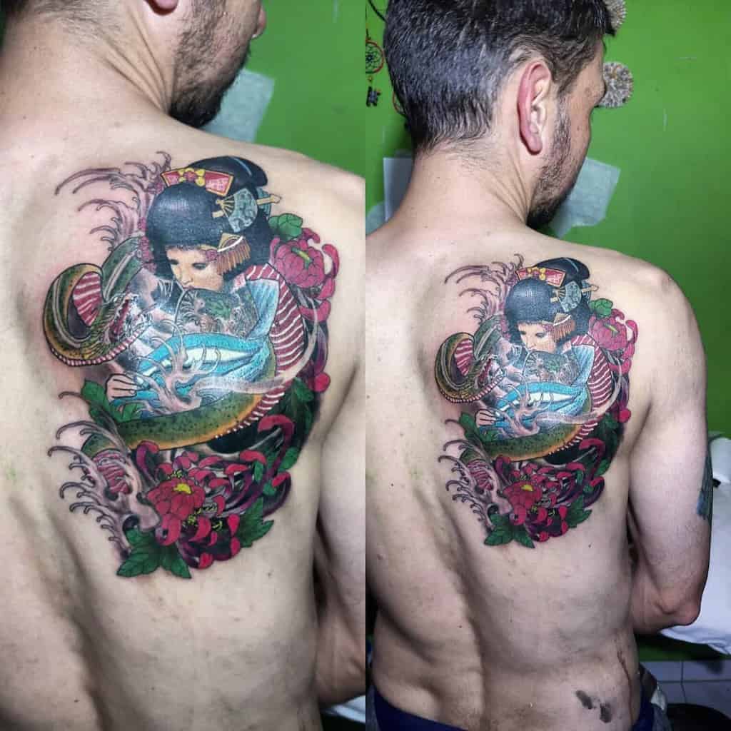 Large, colorful back tattoo of a Geisha holding a glowing sword, surrounded by a serpent, vibrant flowers, and intricate Japanese patterns.