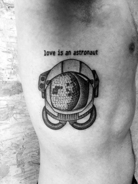 Disco ball inside an astronaut helmet tattoo with 'love is an astronaut' text, blending space and retro themes in a unique blackwork design.