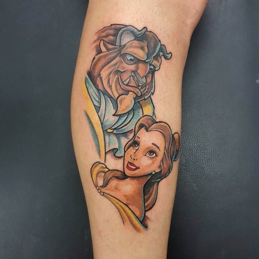 Vibrant tattoo of Belle and the Beast gazing at each other, featuring bold colors and shading for a dynamic Disney-inspired design.