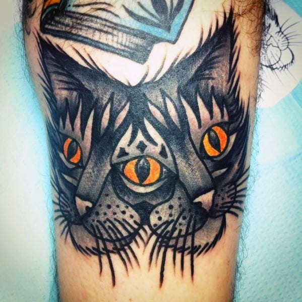 Bold neo-traditional cat tattoo with a third eye and striking orange details, creating a mystical and surreal aesthetic.
