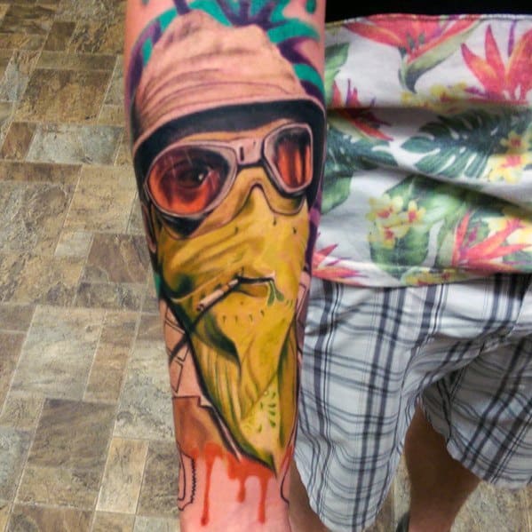 Vibrant Hunter S. Thompson tattoo featuring aviator glasses, a bucket hat, and a surreal, melting face with dripping colors and bold shading.