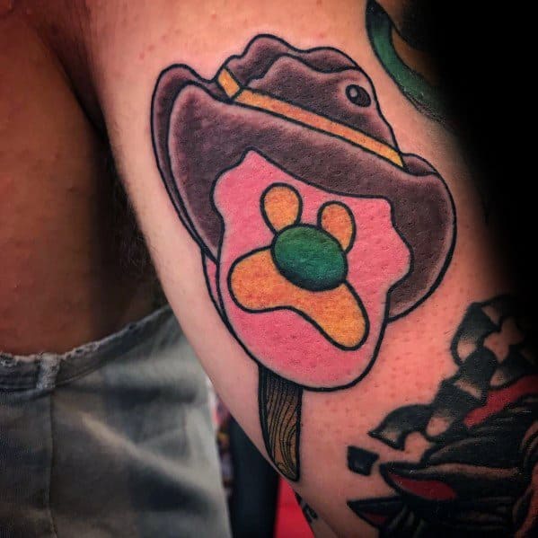 Tattoo of a cowboy-themed ice cream pop shaped like a paw print, topped with a detailed brown hat for a playful Western-inspired design.