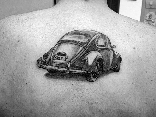 Black and gray tattoo of a classic Volkswagen Beetle on the upper back, viewed from the rear with personalized license plate detail.