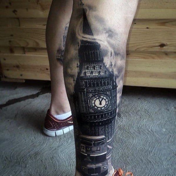 Detailed black and grey tattoo of Big Ben with a vintage London bus at its base, surrounded by dramatic cloud shading on the calf.