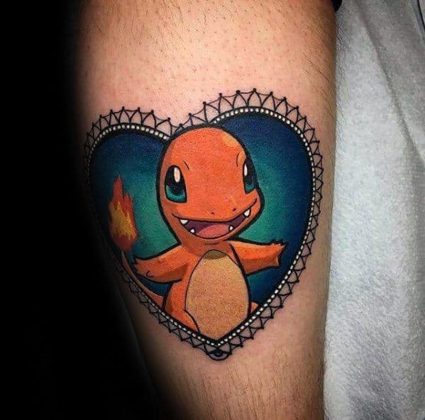 Cute Charmander tattoo inside a heart-shaped lace frame with a teal background, showcasing a joyful pose and bright fiery tail.